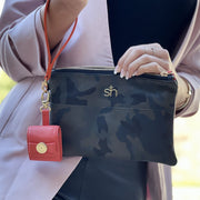 Swatzell + Heilig's AirPod Case in color red, picture showing the paired with an S + H camo handbag