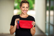Swatzell + Heilig's Make-Up Bag in color Red Poppy, picture showing the bag with a model holding it in her hand