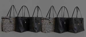 A collection of spacious hand crafted, ethically sourced Italian leather handbags from Swatzell + Heilig, in a line.